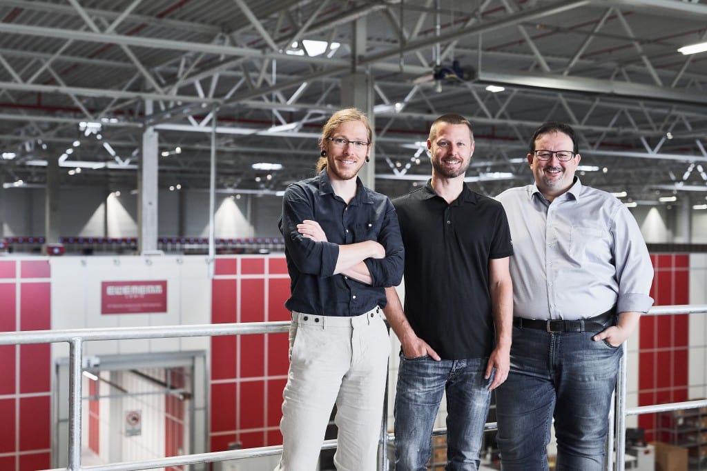 Thomas Klein and Ronny Höhn from Bergfreunde and Michael Kawalier from Element Logic i front of AutoStore grid
